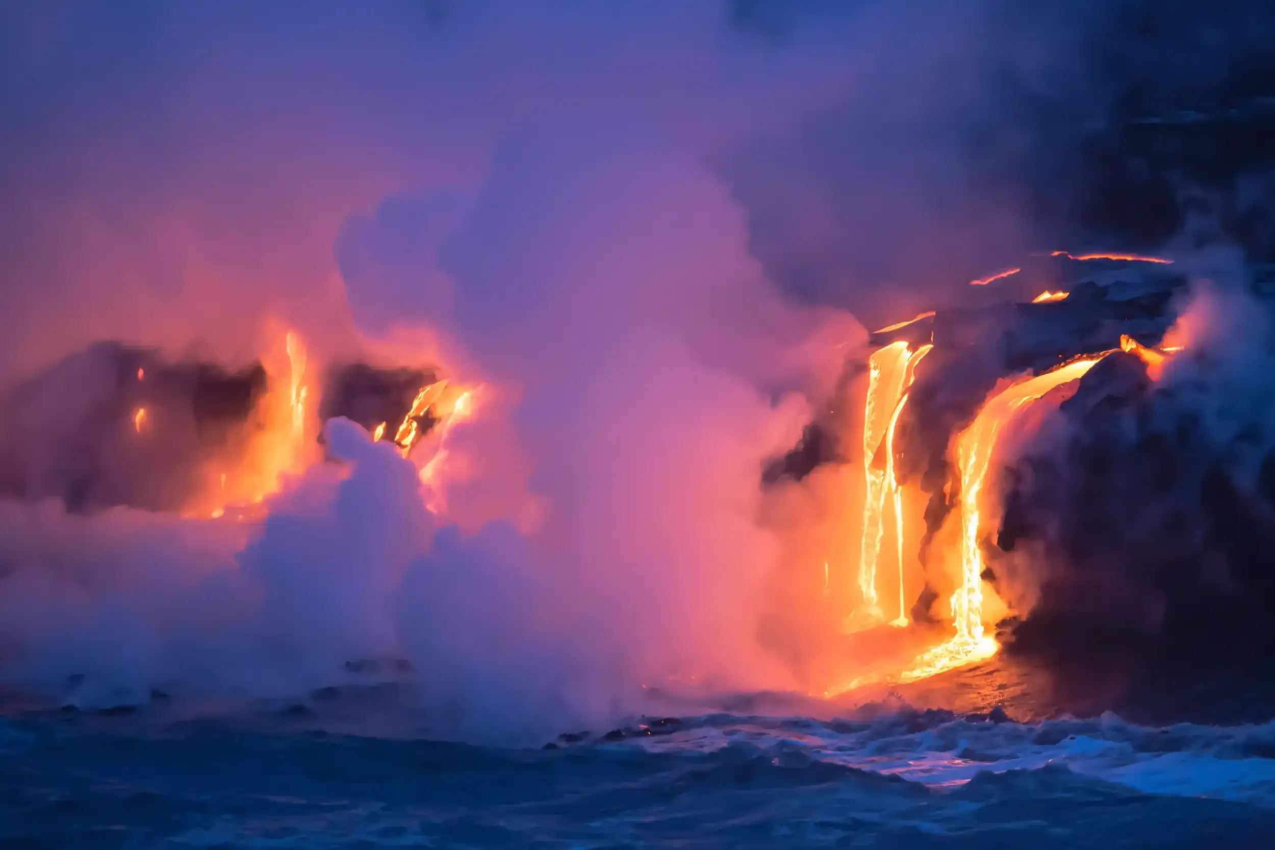 Coulées de lave incandescente se jetant dans l’océan sous un nuage de vapeur