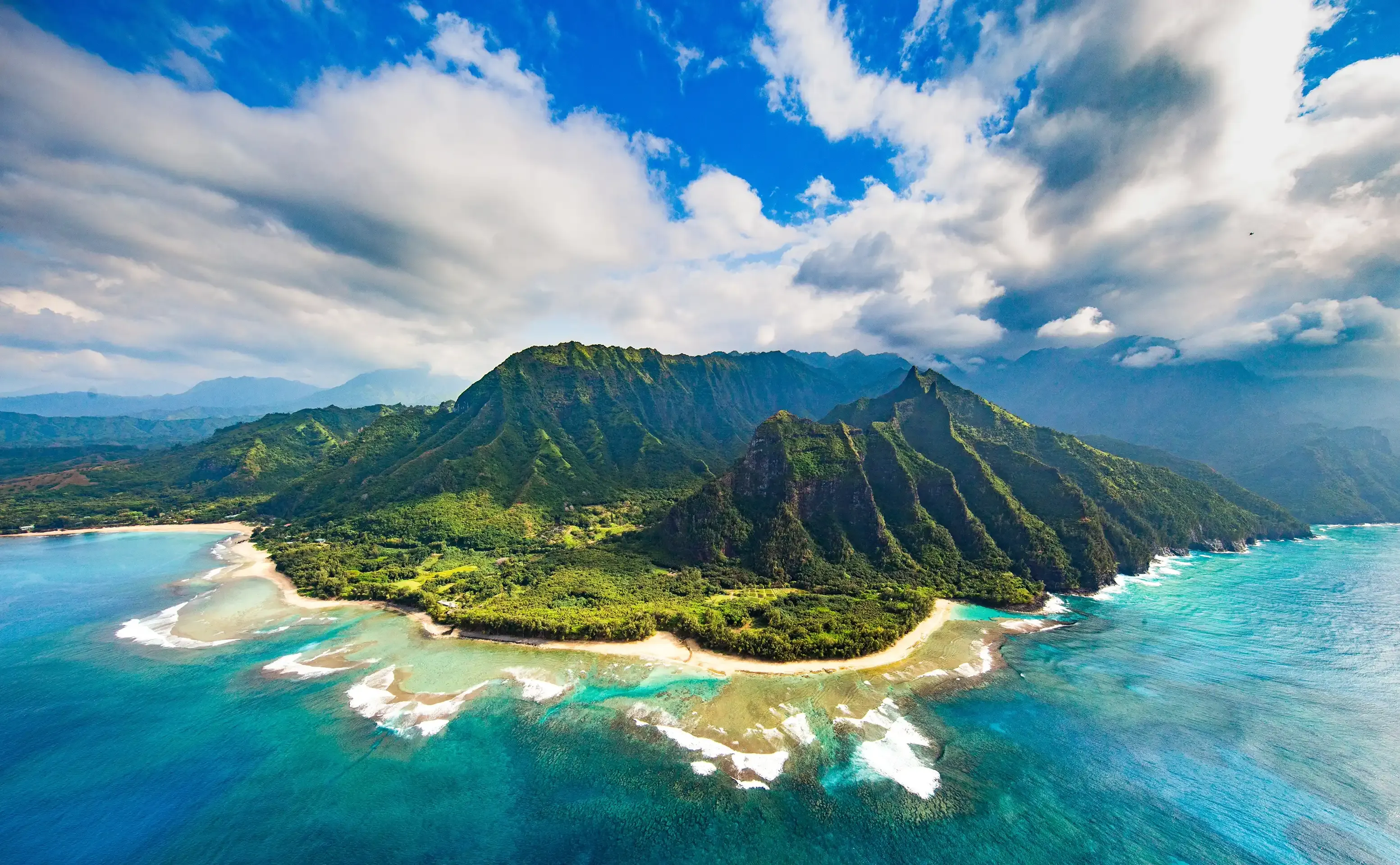 Littoral tropical vu d’avion, récif et eaux turquoise le long d’une côte boisée