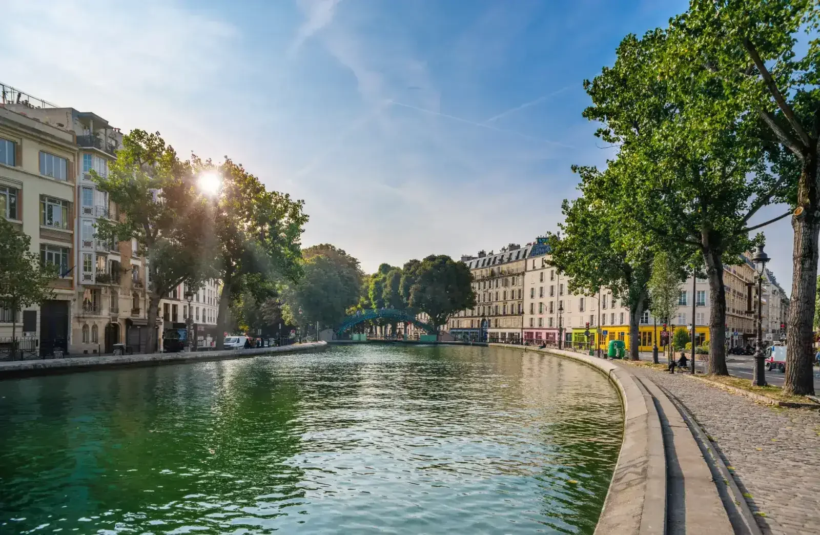 The Canal Saint-Martin in Paris, lined with trees and Haussmann-era buildings