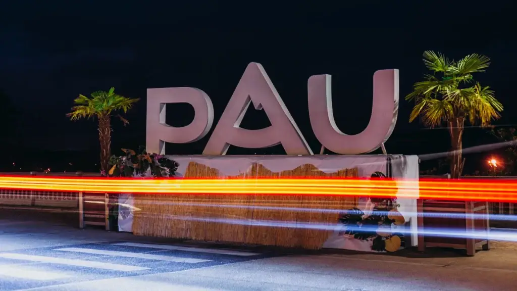 Lettres monumentales formant le mot Pau, éclairées de nuit